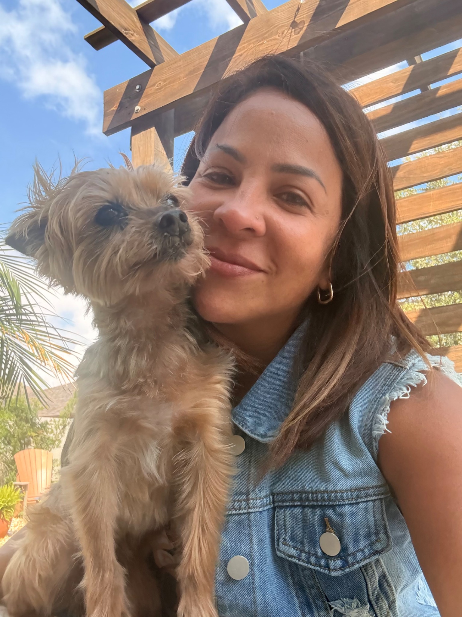 Neida smiling while holding her dog Crystal
